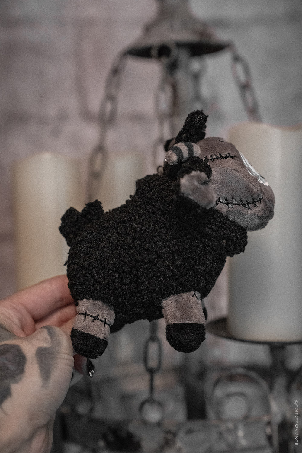 gothic black sheep goat keychain with spiral striped horns and frankenstein stitches 