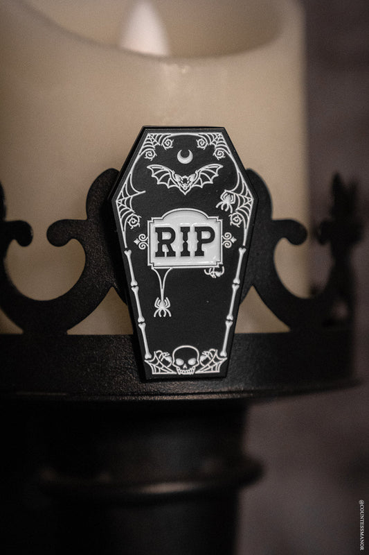 black coffin-shaped enamel pin