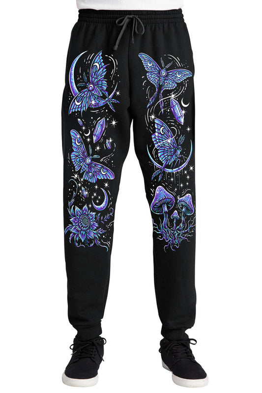 Black sweatpants with a vibrant blue and purple celestial print featuring moths, mushrooms, flowers, and stars, shown on a model from the waist down against a white background.