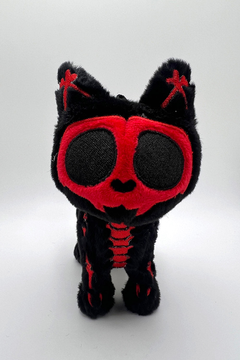 Black and red Skeleton kitty cat plush toy on a white background