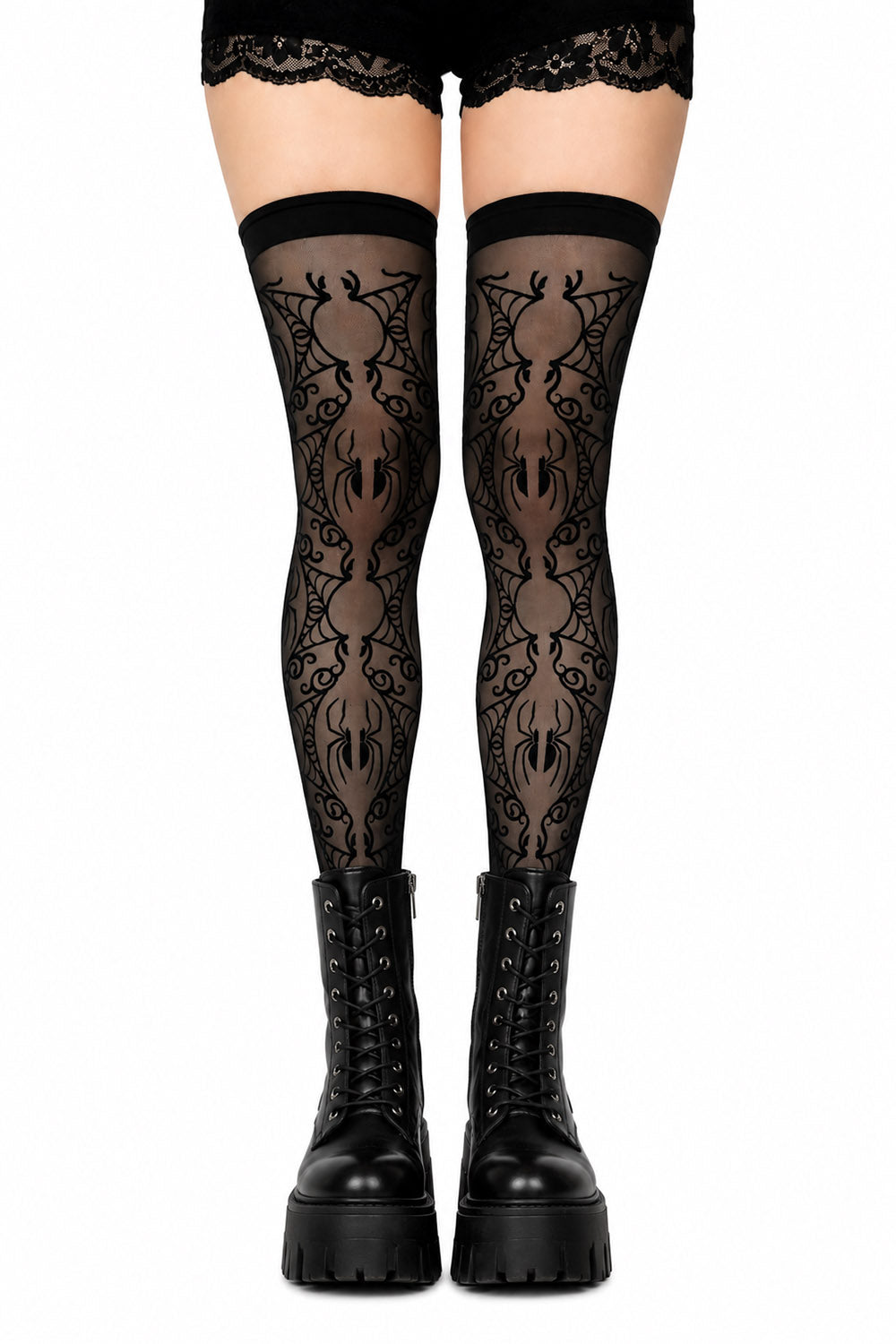 Black lace thigh-high stockings with a repeating spider pattern, worn with black lace-up platform boots against a white background.